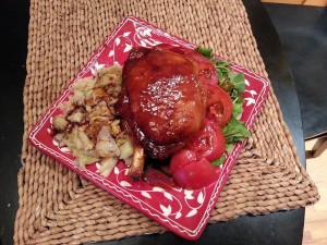 Maple-glazed French-cut bone-in pork chop with cabbage and smashed new potatoes, fresh garden arugula and tomatoes.